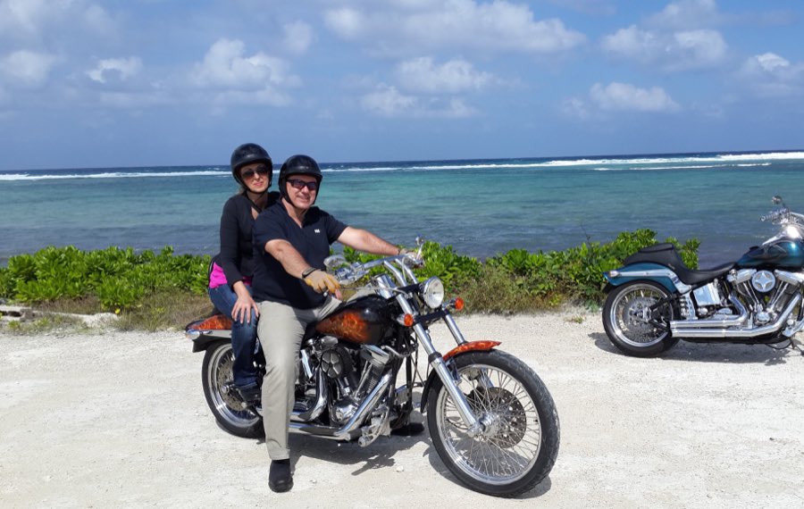Rider and passenger on a custom Harley beside the Grand Cayman coastline