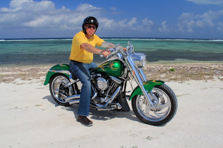 Custom green Harley-Davidson Softail parked on a Grand Cayman beach